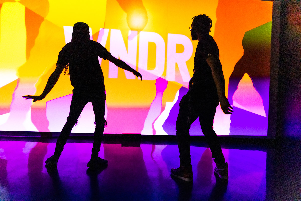 People dancing in front of WNDR exhibit