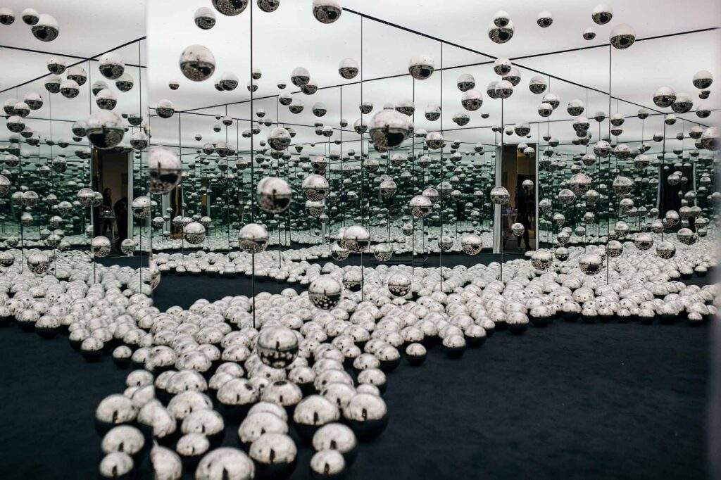 "Let's Survive Forever" consists of a mirrored room with mirrored balls littering the floor and hanging from the ceiling, creating the illusion of endless space.